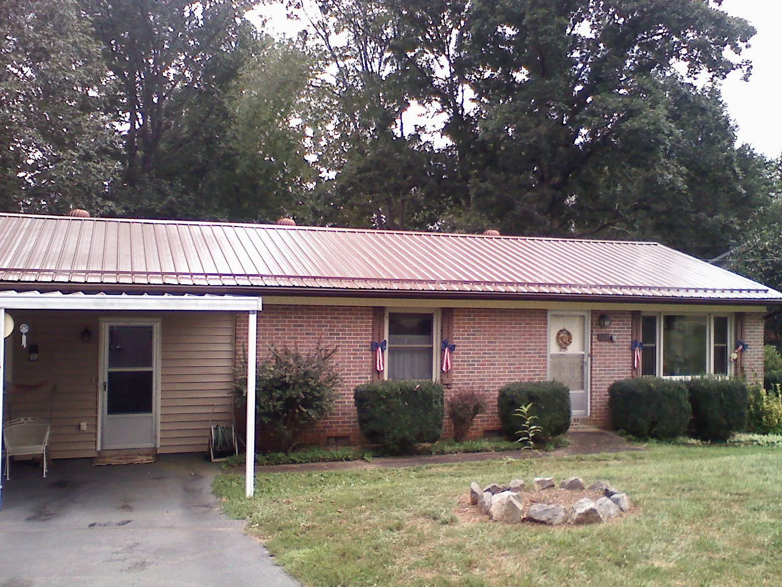 Bronze metal roof and carport on a brick ranch home — Roof Repair work by our crew in Felton